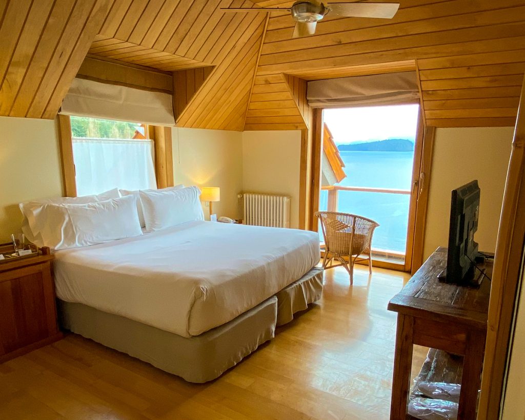 Cama em quarto de hotel com vista para lago