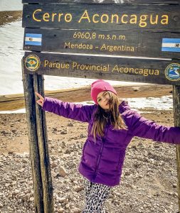 Menina embaixo de placa de braços abertos