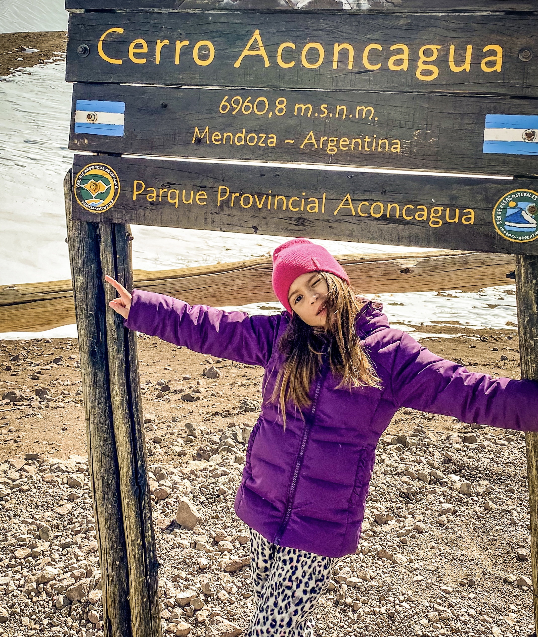 Menina embaixo de placa de braços abertos