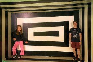 pai e filha em frente a mural de museu