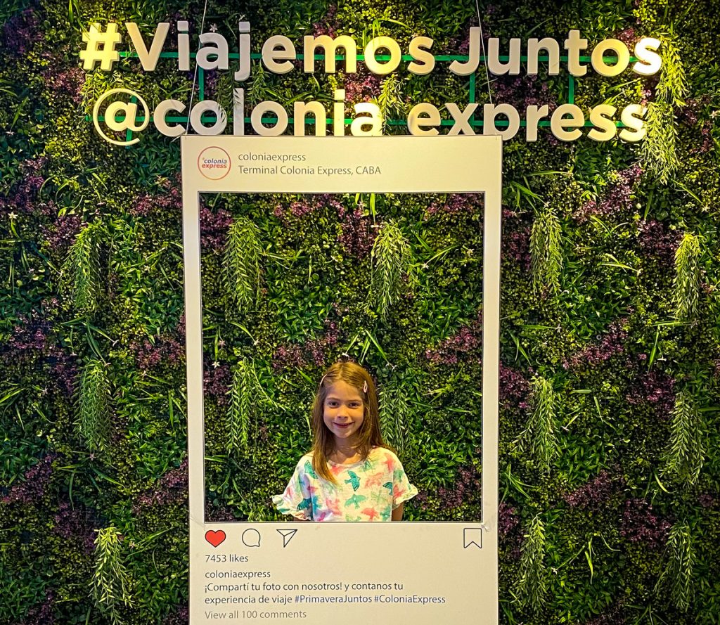 Menina em frente a painel de fotografias