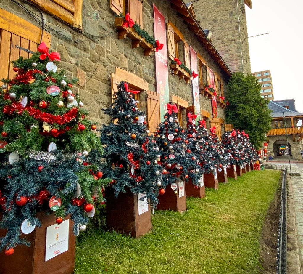 decoração natalina com várias árvores em frente a prédio