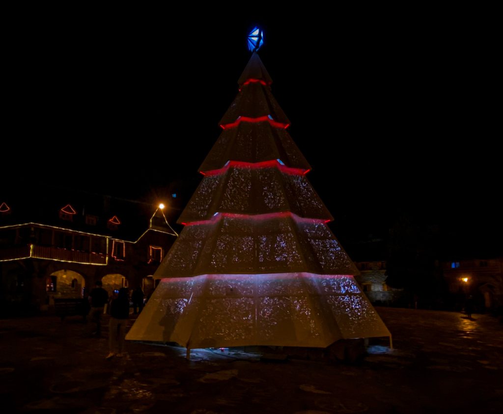 árvore de natal em praça com iluminação baixa a noite