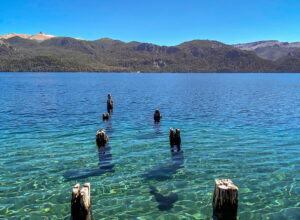 Lago cristalino com tons de azul e montanha ao fundo