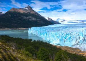 vista de geleira com árvores a frente e montanha ao fundo