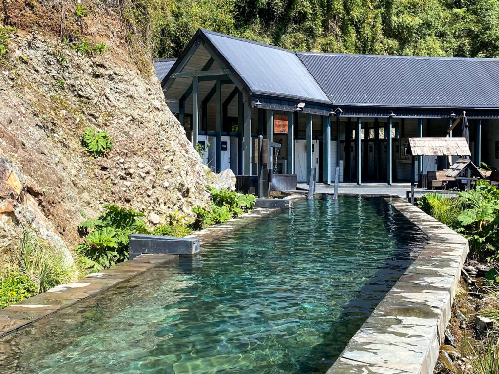 Grabde piscina com estrutura coberta de bar ao fundo