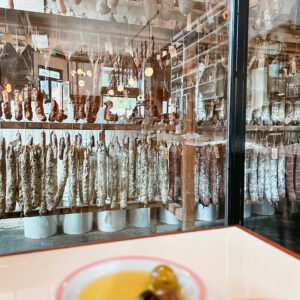 salão de restaurante com salames pendurados em prateleiras