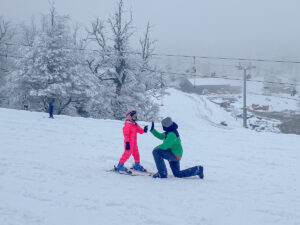 menina e homem com esquis no meio da neve
