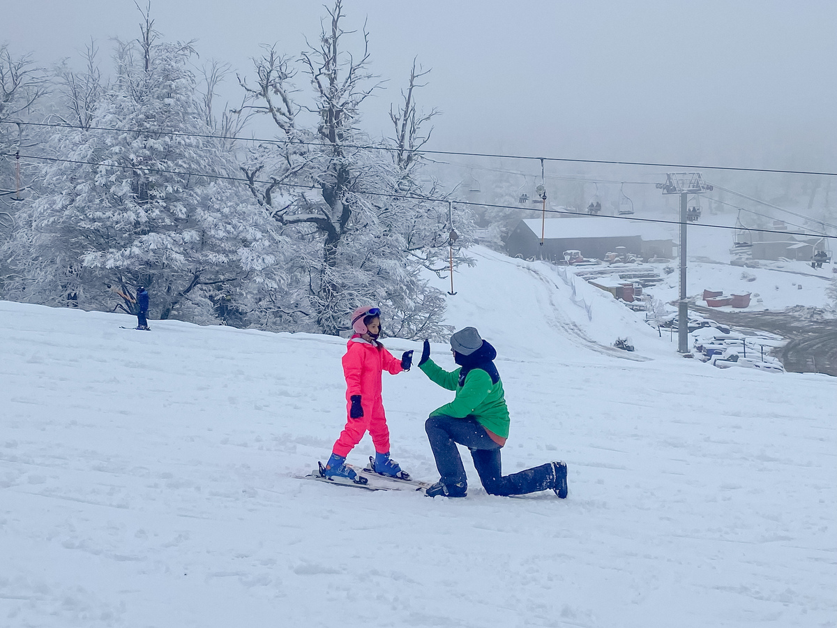 menina e homem com esquis no meio da neve