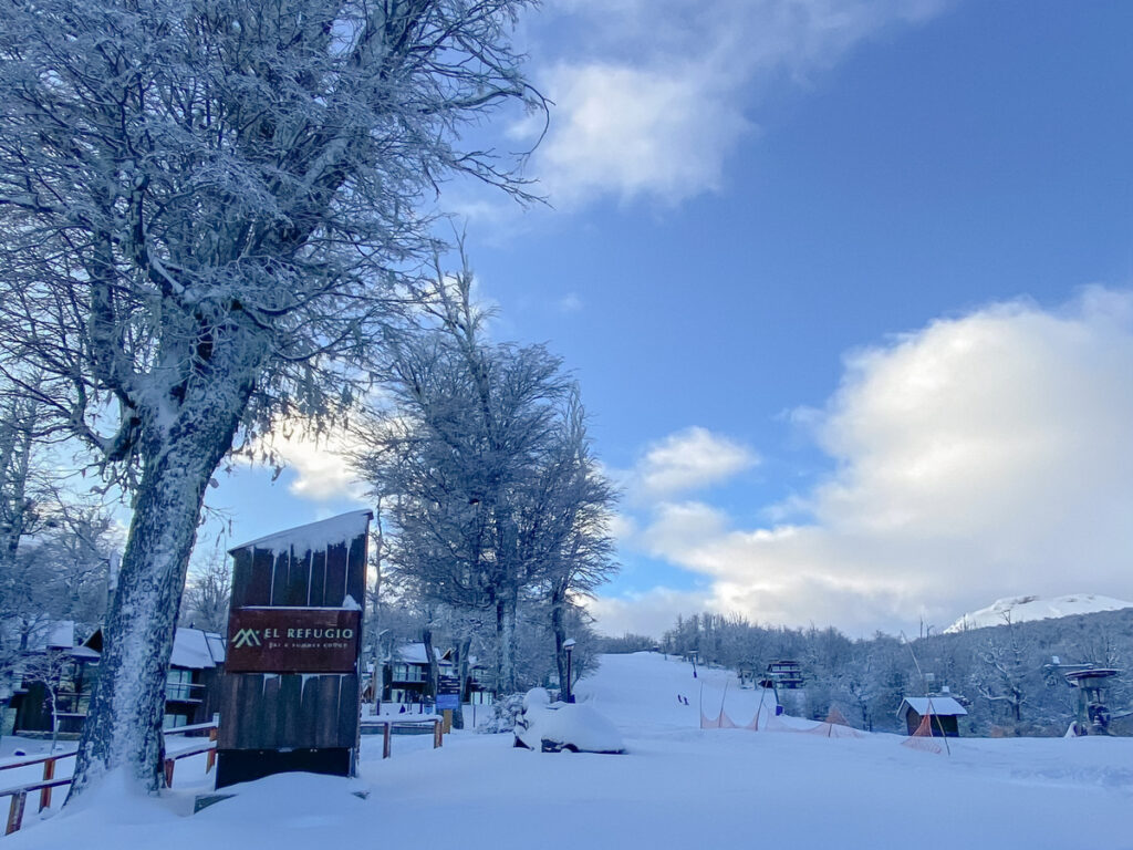 pista de esqui com neve e árvores em primeiro plano