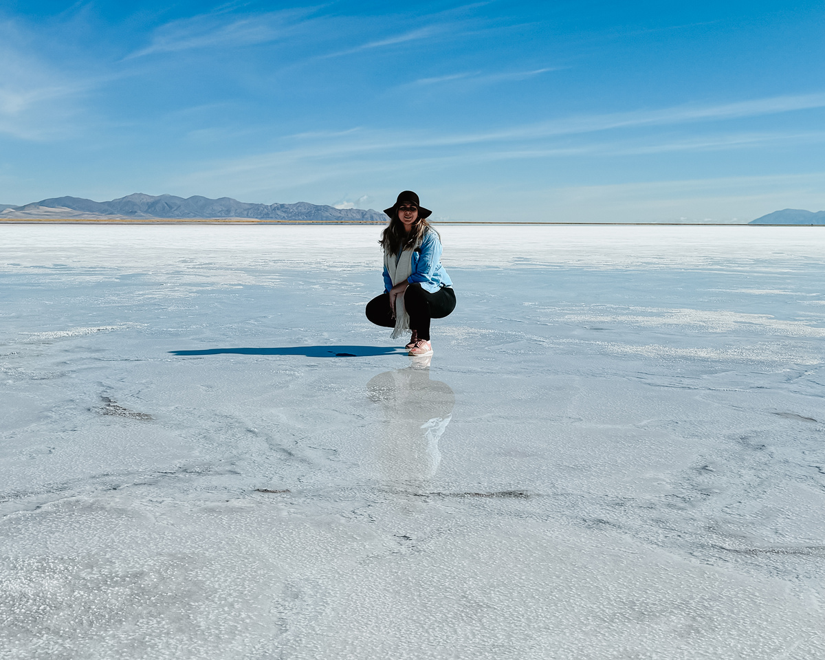 mulher abaixada em salar infinito