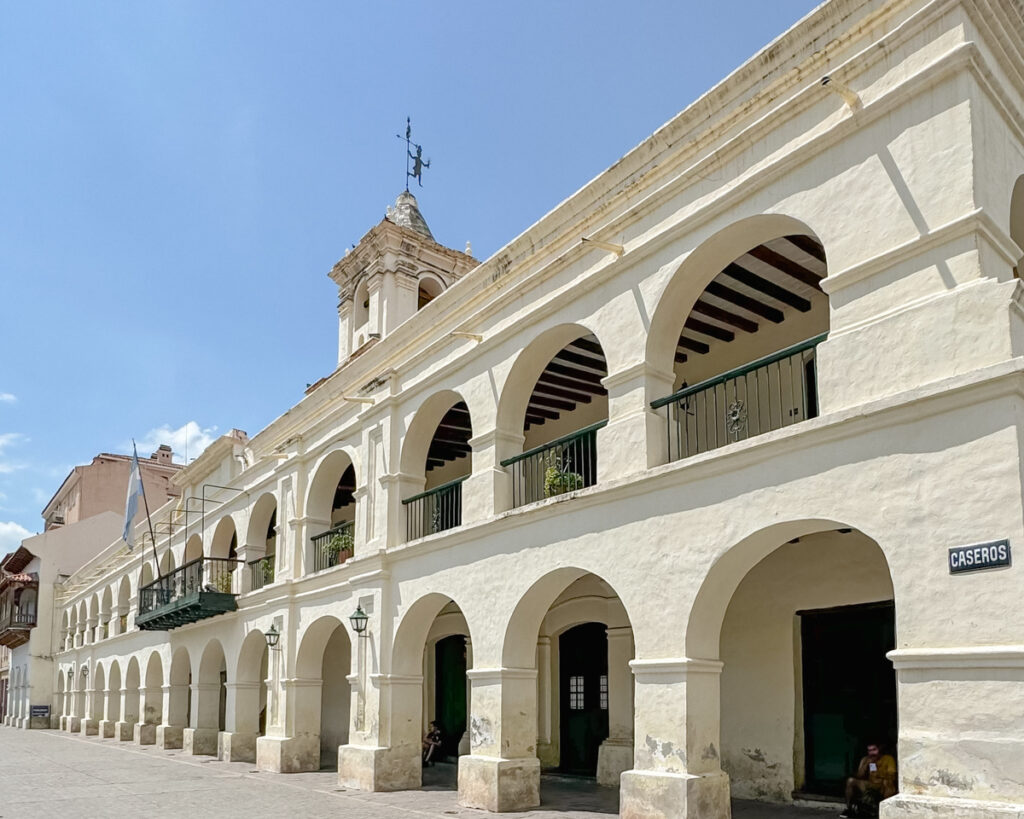 Prédio histórico com arcos e torre ao fundo