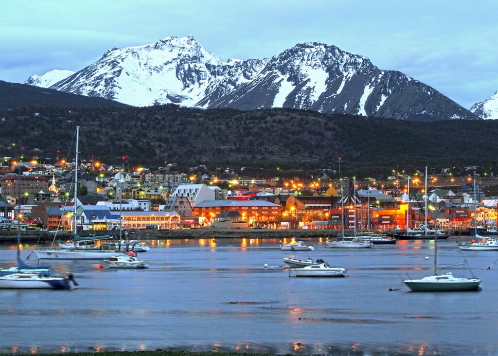 cidade de frente para o mar com montanha de neve ao fundo