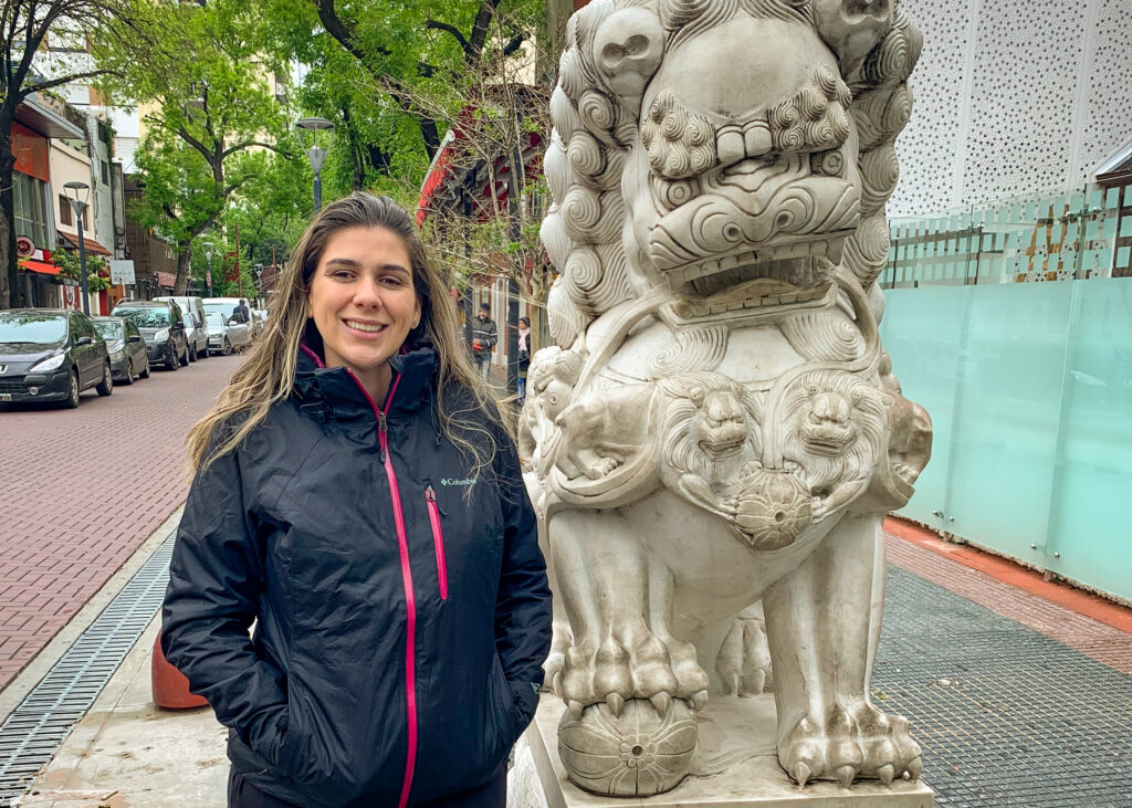 mulher sorrindo ao lado de estátua