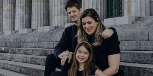mãe, pai e menina em escadaria