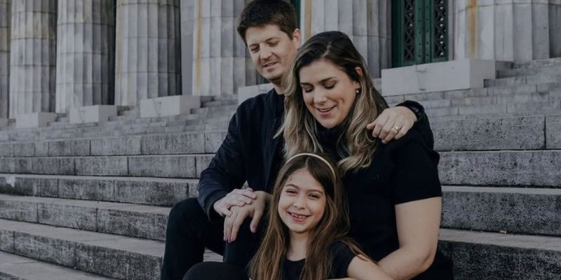 mãe, pai e menina em escadaria