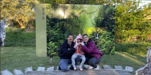 familia com pai, mãe e filha com painel verde de floresta ao fundo