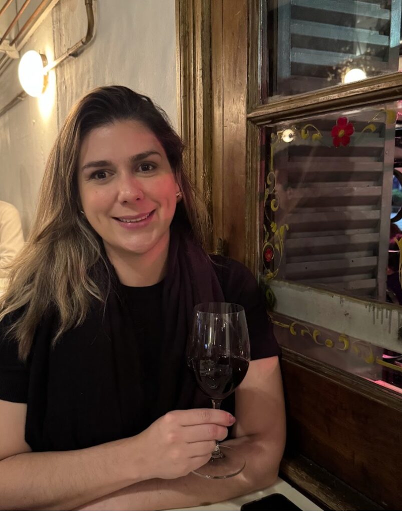 mulher com taça de vinho sentada em mesa de restaurante